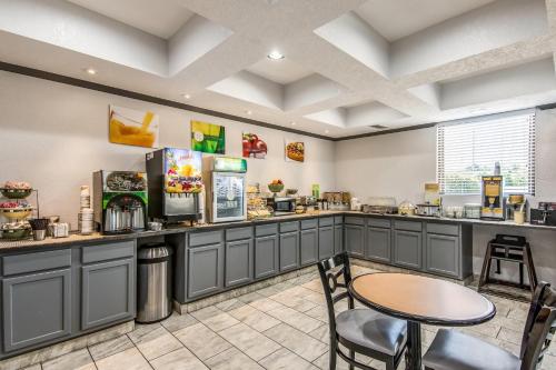 un restaurant avec un comptoir, une table et des chaises dans l'établissement Quality Suites Maumelle - Little Rock Northwest, à Maumelle