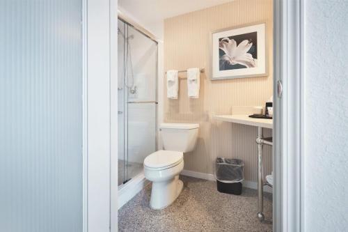 a bathroom with a white toilet and a shower at Fort Pontchartrain Detroit, a Wyndham Hotel in Detroit