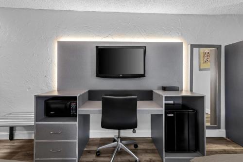 an office with a desk and a tv on a wall at Quality Inn Bangor Airport in Bangor