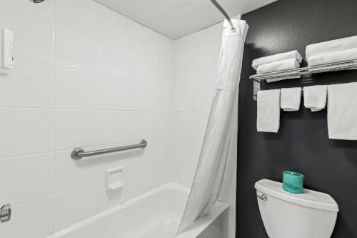 a bathroom with a tub and a toilet and towels at Quality Inn Bangor Airport in Bangor