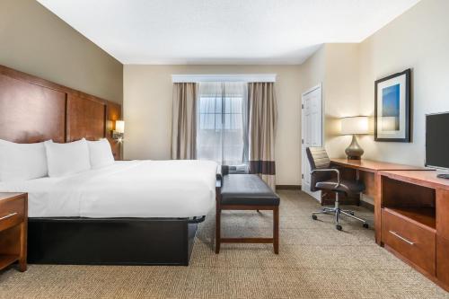 a hotel room with a bed and a desk at Comfort Suites Myrtle Beach Central in Myrtle Beach