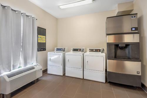 a laundry room with three washers and a oven at Comfort Suites Myrtle Beach Central in Myrtle Beach