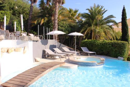 a swimming pool with chairs and umbrellas in a yard at Royal Cottage in Cassis