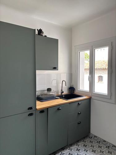 une cuisine avec un évier et un réfrigérateur dans l'établissement Boudoir Antibes walking distance beach & antibes, à Antibes