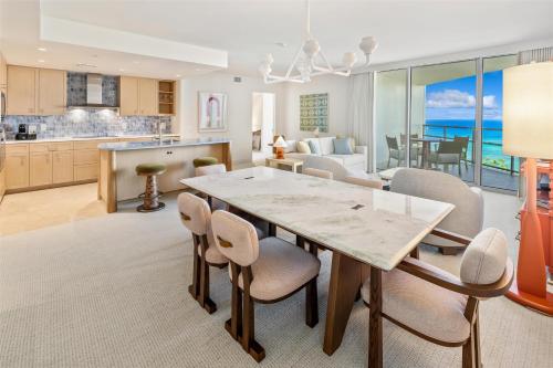 a kitchen and dining room with a table and chairs at Ka Laʻi Waikiki Beach, LXR Hotels & Resorts in Honolulu