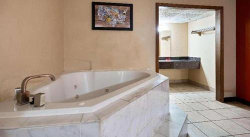 a large white bath tub in a bathroom at SureStay Hotel in Salina
