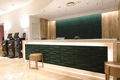 a bar with a green wall in a salon at Hiyori Hotel Osaka Suminoekoen Station in Osaka