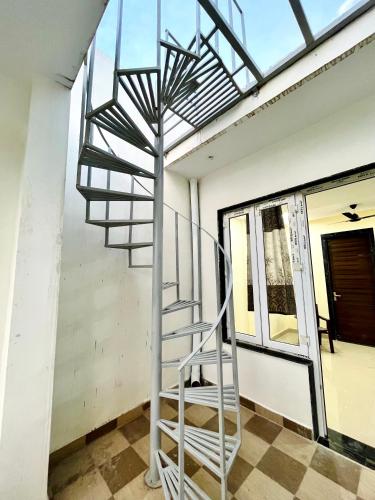 a metal spiral staircase in a room with a window at Nidhivan Niwas in Chhatikara