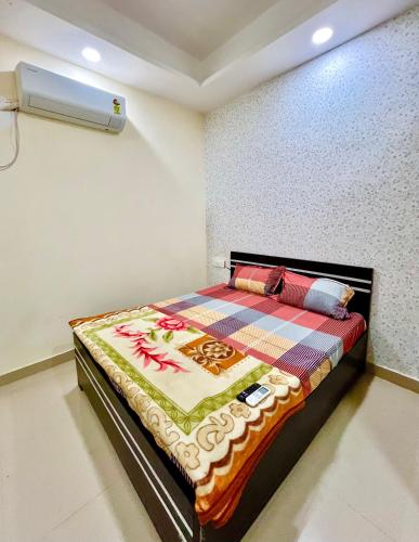 a bedroom with a bed with a quilt on it at Nidhivan Niwas in Chhatikara
