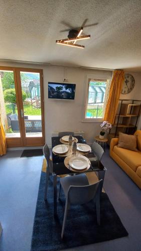 a living room with a table and chairs and a couch at Les Epicuriens in Bielle
