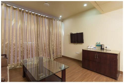 a living room with a glass table and a television at A Premium Hotel FAIRWAY Near Railway Station - Well Decorated & Spacious Rooms - Lift # Restaurant # Free Parking And Free Wi-fi Available - A Top Rated Hotel In Amritsar in Amritsar