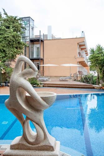 a statue sitting next to a swimming pool at Morlans Garden in Paguera