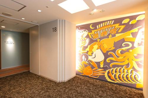 a hallway with a large painting on the wall at Hiyori Hotel Osaka Suminoekoen Station in Osaka