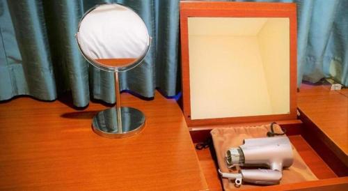 a mirror sitting on top of a wooden table at Hotel Harvest In Yonago in Yonago