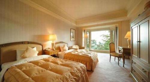 a hotel room with two beds and a window at Hotel de Premiere Minowa in Inawashiro