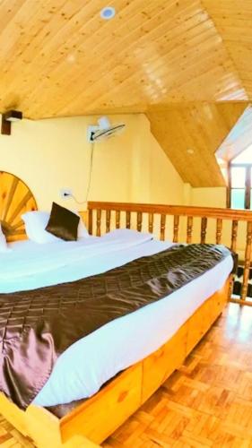 a bedroom with two beds and a wooden ceiling at Chand Guest house in Kasol