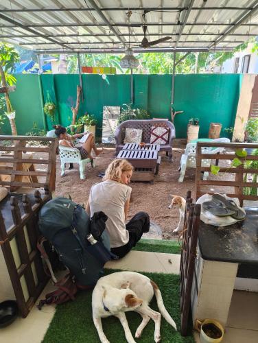 a woman sitting on the floor next to a dog at JeeHaa Homestay in Alleppey