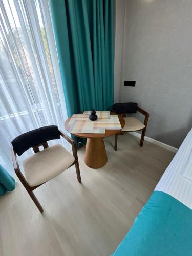 a room with a table and a chair and a bed at Bamboo Beach Luxury Two Queens in Tsikhisdziri
