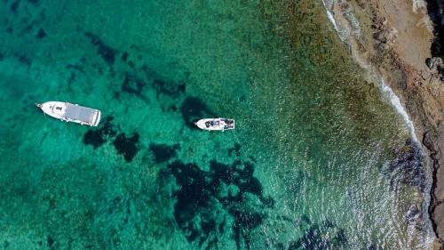 two boats sitting in the ocean near the shore at Villa Eden Palms, Coral-Bay, Pool in Peyia