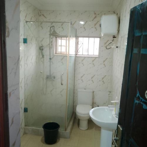 a bathroom with a shower and a toilet and a sink at Peace Home in Lekki