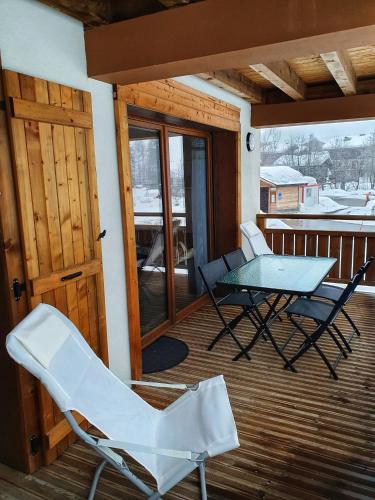 un patio avec une table et des chaises sur une terrasse dans l'établissement Croisse Baulet Pied des pistes Parking 3 épis, à La Giettaz
