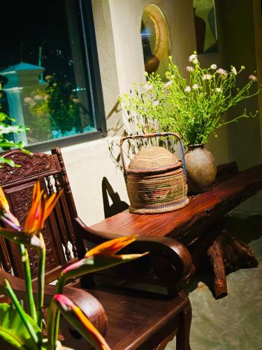 a hat sitting on a wooden table with plants at Ananda Home in Tân Hiệp