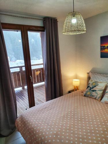 une chambre avec un lit et un lustre dans l'établissement Croisse Baulet Pied des pistes Parking 3 épis, à La Giettaz