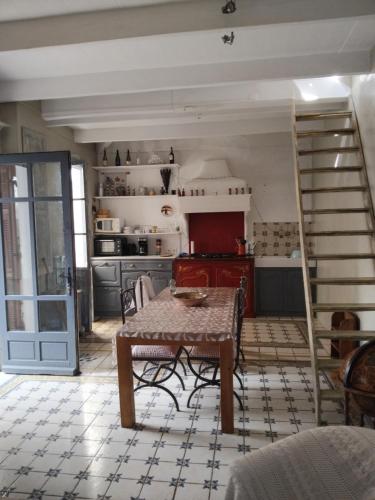 - une cuisine avec une table et un escalier dans une chambre dans l'établissement Maison authentique, à Nice