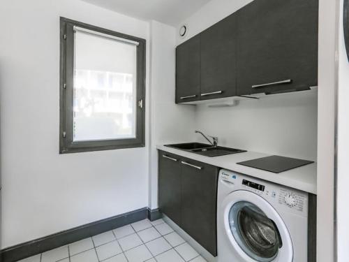 cocina con lavadora y ventana en Residence l 'agora, en Vaux-sur-Mer