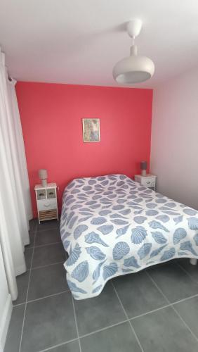 une chambre avec un lit et un mur rouge dans l'établissement Residence l 'agora, à Vaux-sur-Mer