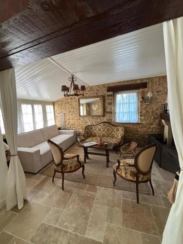 - un salon avec un canapé et des chaises dans l'établissement Corps de ferme rénové à 10 min de Sarlat, à Carsac-Aillac