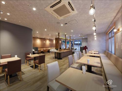 a dining room with tables and chairs and a restaurant at Daiwa Roynet Hotel Osaka-Uehonmachi in Osaka