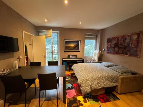 Un dormitorio con una cama y una mesa y un comedor. en Chamonix city center rue Paccard, en Chamonix-Mont-Blanc
