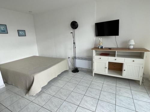 une chambre avec un lit et une télévision à écran plat dans l'établissement Studio Héliopolis C 36 - 4 personnes, au Cap d'Agde