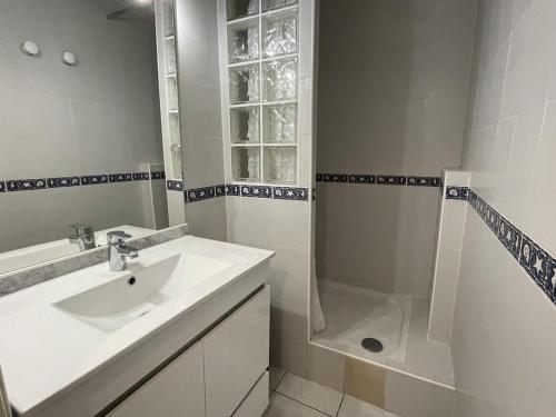 une salle de bain blanche avec un lavabo et une douche dans l'établissement Studio Héliopolis C 36 - 4 personnes, au Cap d'Agde