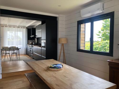 une cuisine et une salle à manger avec une table en bois dans l'établissement Maison KERLINA finistere pointe du raz Bretagne vue mer, à Plogoff
