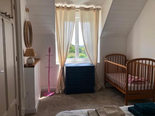 une chambre avec une fenêtre et deux berceaux et un berceau dans l'établissement Maison KERLINA finistere pointe du raz Bretagne vue mer, à Plogoff
