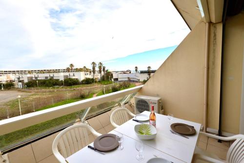 d'un balcon avec une table et des chaises blanches ainsi qu'une fenêtre. dans l'établissement Studio Héliopolis D 51 - 4 personnes, au Cap d'Agde