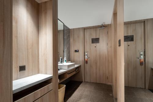 a bathroom with a sink and a mirror at Atour Hotel Qingdao Olympic Sailing Center May Fourth Square in Qingdao