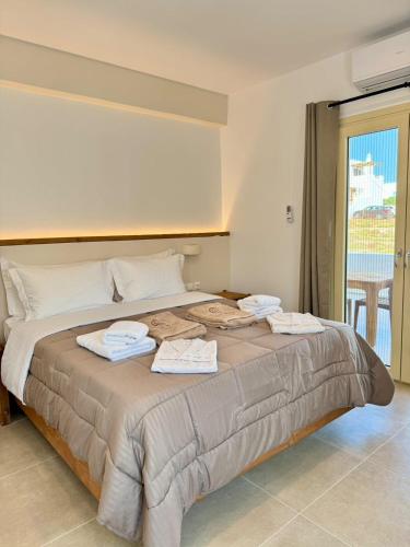 a bedroom with a large bed with towels on it at Vive Mare Milos in Pachaina