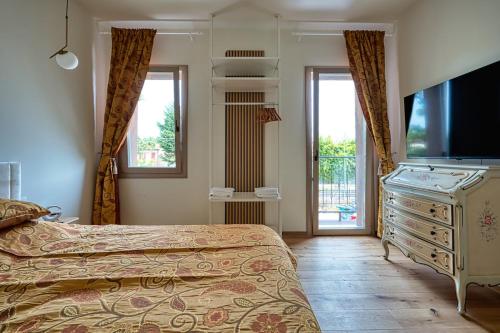 a bedroom with a bed and a dresser with a television at Romantic Garden Venice Ap 2 Free Parking in Venice