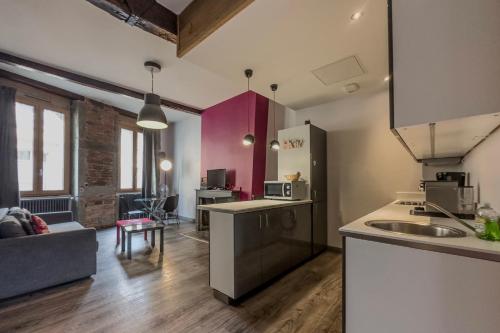 a kitchen and living room with a couch and a table at #HX L'Escapade des Clercs in Grenoble