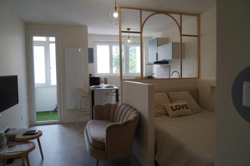 une chambre avec un lit, une chaise et un miroir dans l'établissement Les 20 bonheurs - Cosy pour 2 pers - Check-in 24-24, à Aubière