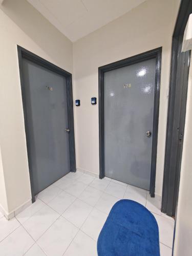 two glass doors in a room with a blue chair at MixxHome Seremban 2, Two Single Beds, Share Bathroom in Seremban