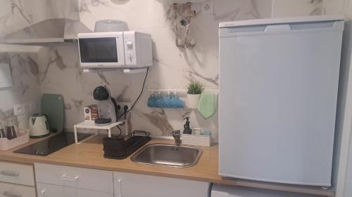 a kitchen counter with a sink and a microwave at Aguadulce Montse in Aguadulce