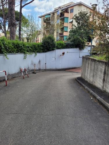 an empty street with a white wall and a building at Panoramico Eur in Rome