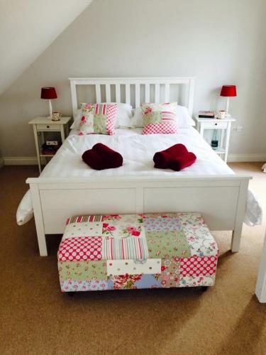 a white bed with pillows and a bench in a bedroom at Number 2 Lymington Hampshire in Lymington