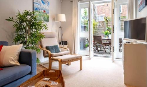 a living room with a blue couch and a tv at Number 2 Lymington Hampshire in Lymington