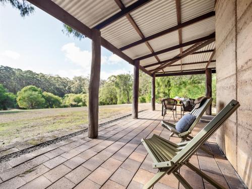 a patio with two chairs and a table on it at Marima Cottages in Pemberton