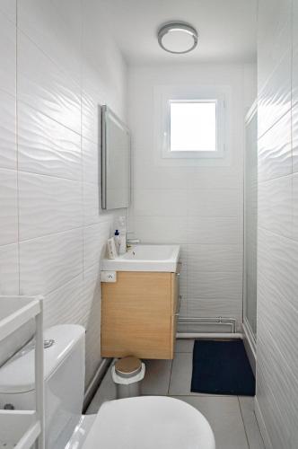 une salle de bain blanche avec un lavabo et des toilettes dans l'établissement Maison meublé avec jardin, à Talence